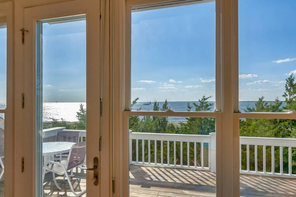 An outdoor deck area furnished for relaxation and entertainment, overlooking a serene ocean view. The furniture is arranged to encourage lounging, conversation, and taking in the tranquil scenery and ocean breezes.